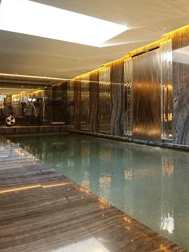 Mason fitting an indoor swimming pool with luxury stone